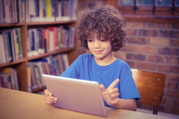 Allievo sveglio facendo uso della compressa nella biblioteca