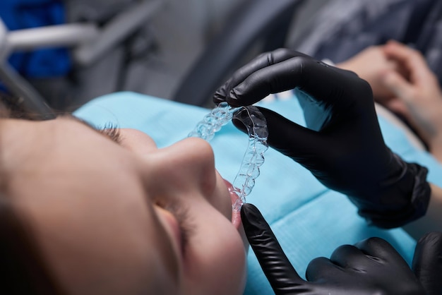 Allineatore invisibile della bambina caucasica e che indica i suoi denti dritti perfetti. Salute dentale e concetto di fiducia.