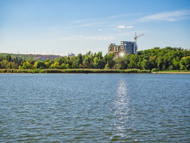 Alloggio ecologico in un'area del parco. Edifici vicino al lago. Costruzione di edifici moderni. Il concetto di alloggio ecologico.