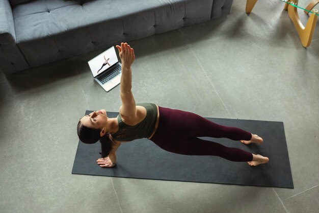 Allungamento. Bella giovane donna sportiva che pratica le asana dello yoga come un professionista a casa.