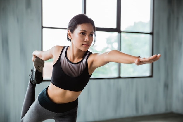 Allungamento della donna di sport nell'usura di sport all'interno