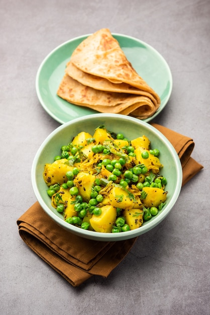 Aloo Mutter o Matar aalu dry sabzi, patate indiane e piselli fritti insieme alle spezie e guarniti con foglie di coriandolo. servito con roti o chapati