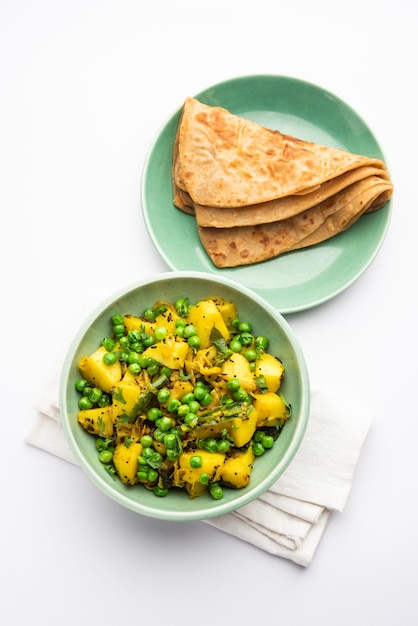 Aloo Mutter o Matar aalu dry sabzi, patate indiane e piselli fritti insieme alle spezie e guarniti con foglie di coriandolo. servito con roti o chapati