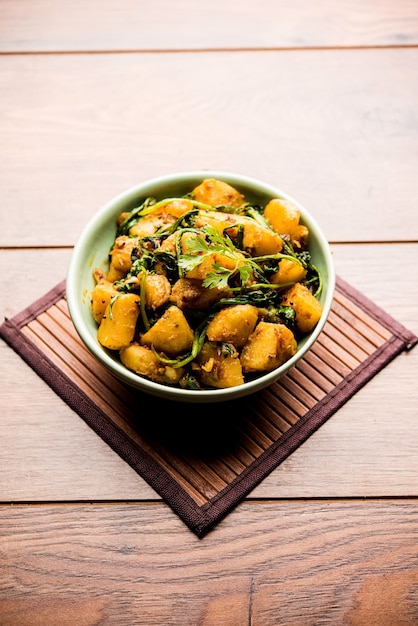 Aloo Palak sabzi - Patata cotta con spinaci con aggiunta di spezie. una sana ricetta del piatto principale indiano. Servito in una ciotola, messa a fuoco selettiva