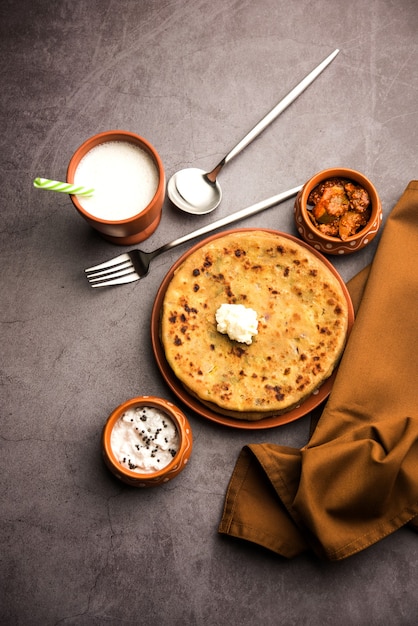 Aloo Paratha o focaccia ripiena di patate indiane con burro sopra. Servito con Lassi dolce fresco, chutney e sottaceti. messa a fuoco selettiva