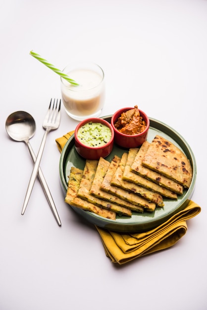 Aloo Paratha o focaccia ripiena di patate indiane con burro sopra. Servito con Lassi dolce fresco, chutney e sottaceti. messa a fuoco selettiva