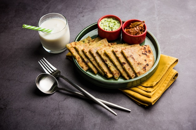 Aloo Paratha o focaccia ripiena di patate indiane con burro sopra. Servito con Lassi dolce fresco, chutney e sottaceti. messa a fuoco selettiva