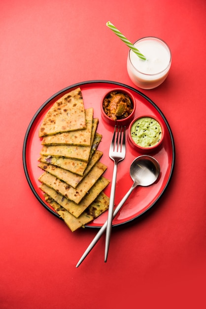 Aloo Paratha o focaccia ripiena di patate indiane con burro sopra. Servito con Lassi dolce fresco, chutney e sottaceti. messa a fuoco selettiva