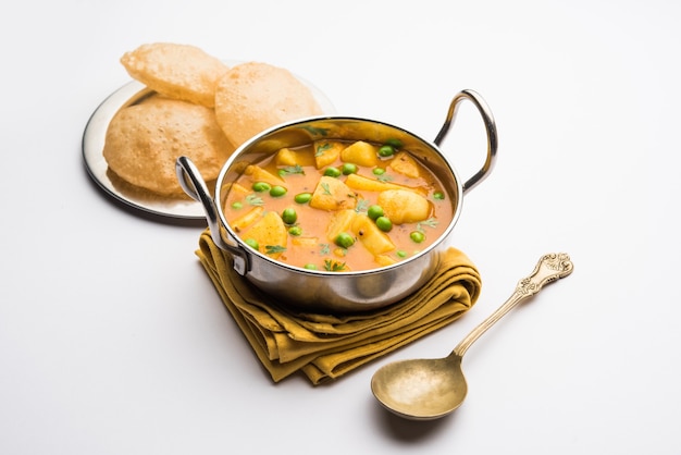 Aloo Puri o curry di patate con Poori fritto, popolare colazione indiana o menu per pranzo o cena.