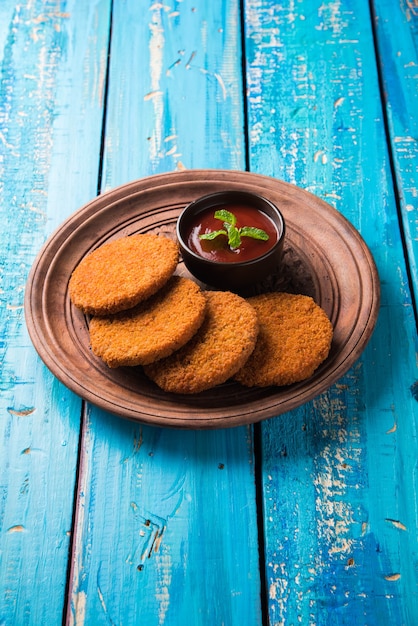 Aloo Tikki o Patties o Cutlet è uno spuntino o uno spuntino popolare dall'India, servito con ketchup di pomodoro o chutney di Imli su uno sfondo lunatico. Messa a fuoco selettiva