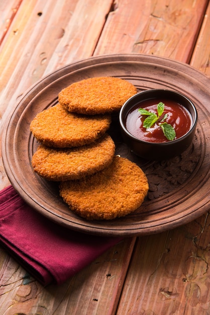 Aloo Tikki o Patties o Cutlet è uno spuntino o uno spuntino popolare dall'India, servito con ketchup di pomodoro o chutney di Imli su uno sfondo lunatico. Messa a fuoco selettiva