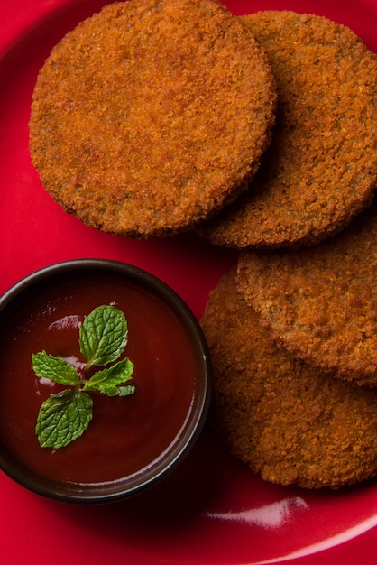 Aloo Tikki o Patties o Cutlet è uno spuntino o uno spuntino popolare dall'India, servito con ketchup di pomodoro o chutney di Imli su uno sfondo lunatico. Messa a fuoco selettiva