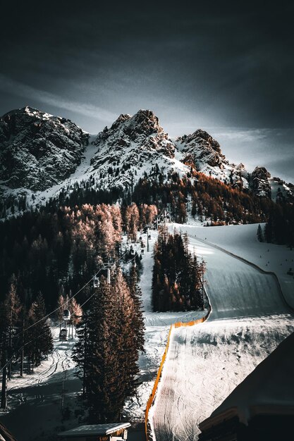 Alpi italiane e piste da sci nelle dolomiti con cielo malinconico e neve