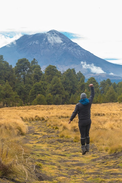 Alpinista che cammina sulla montagna con vista sul vulcano popocatepetl