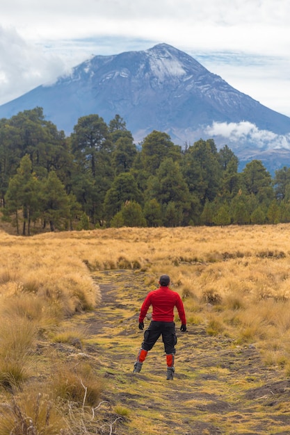 Alpinista che cammina sulla montagna con vista sul vulcano popocatepetl