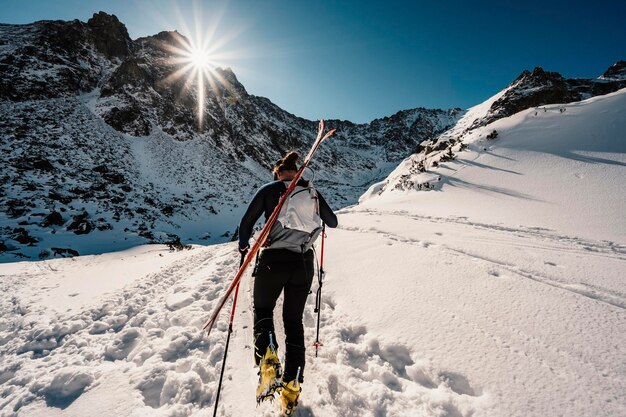 Alpinista sci di fondo passeggiate sci alpinista in montagna Sci alpinismo nel paesaggio alpino con alberi innevati Avventura sport invernali Alti Tatra slovacchia paesaggio