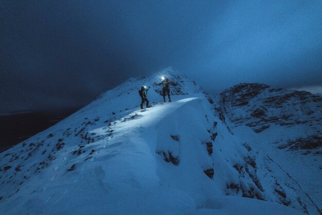 Alpinisti trekking nella fredda notte a Liathach Ridge, Scozia