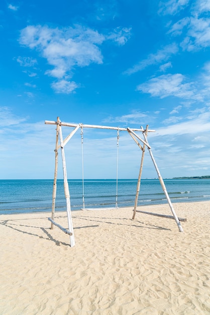 altalena in legno sulla spiaggia con sfondo mare spiaggia