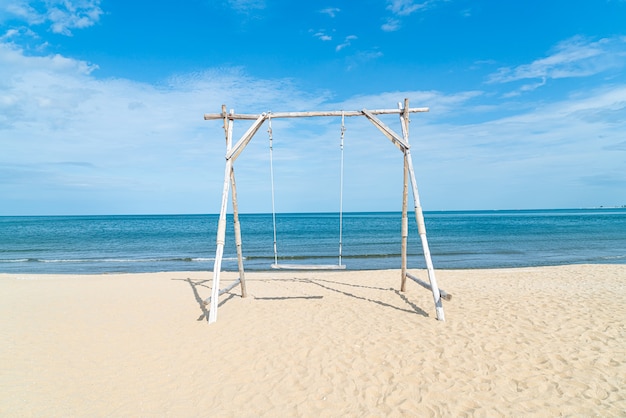 altalena in legno sulla spiaggia con sfondo spiaggia mare