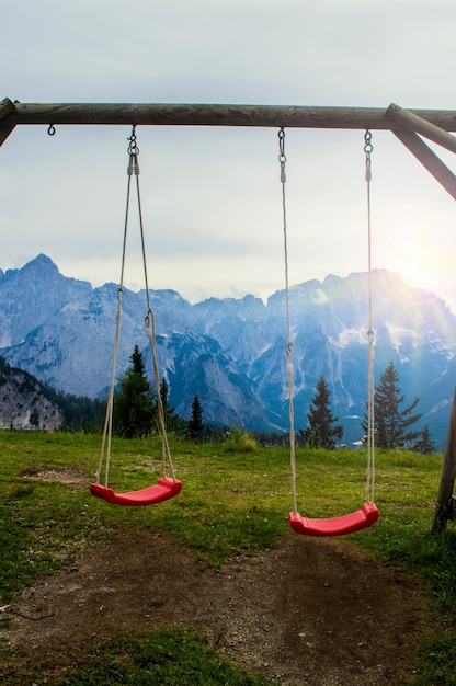 Altalena per bambini su uno sfondo di montagne alpine