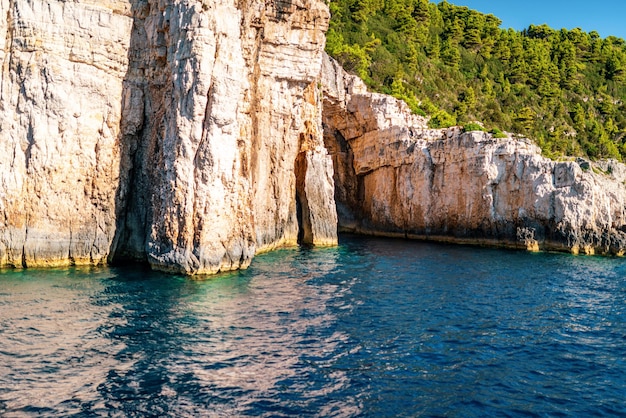 Alte scogliere con foresta e rocce sulla riva dell'isola di Corfù