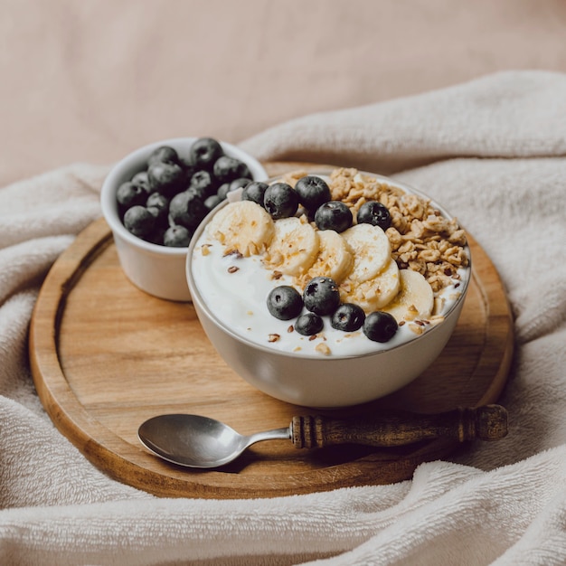 Alto angolo di colazione a letto con cereali e mirtilli