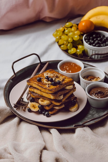 Alto angolo di colazione a letto con pane tostato e banana