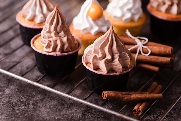 Alto angolo di deliziosi cupcakes con bastoncini di cannella