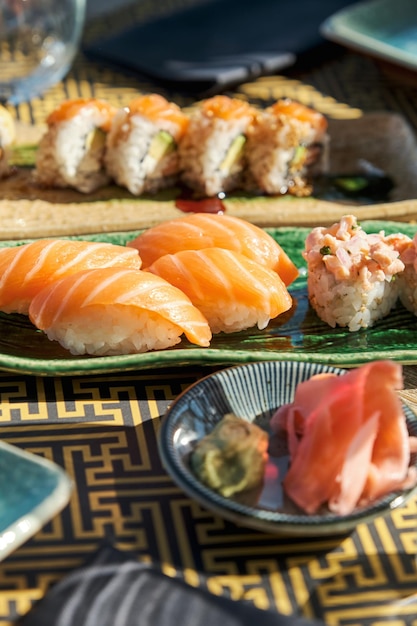 Alto angolo di gustosi rotoli di sushi con pesce servito sul piatto sul tavolo in un ristorante