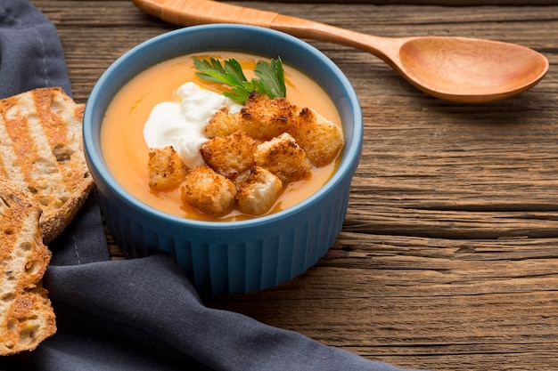 Alto angolo di zuppa di zucca invernale con crostini di pane