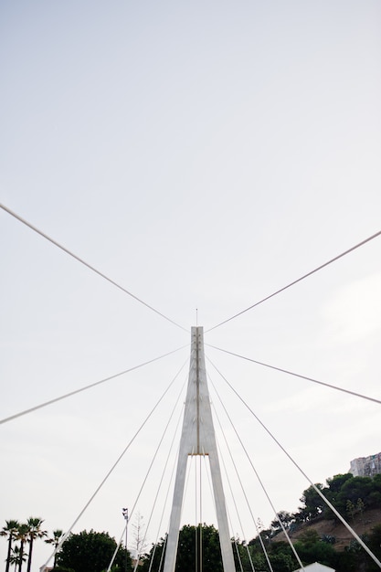 Alto ponte bianco in una città. Foto ravvicinata delle sue corde.