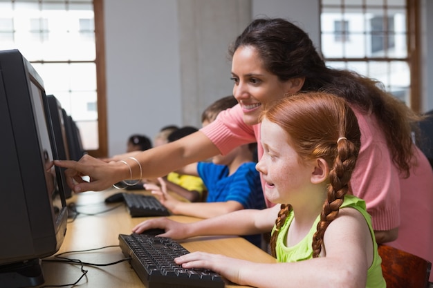 Alunni carini nella classe del computer con l&#39;insegnante