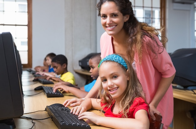 Alunni carini nella classe del computer con l&#39;insegnante