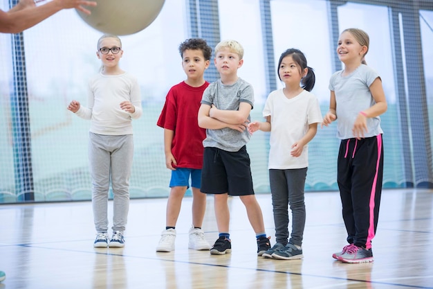 Alunni in classe di ginnastica che guardano l'insegnante