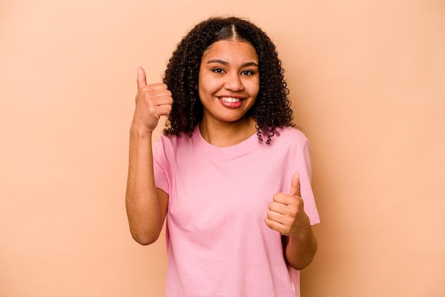 Alzando entrambi i pollici in su sorridente e fiducioso