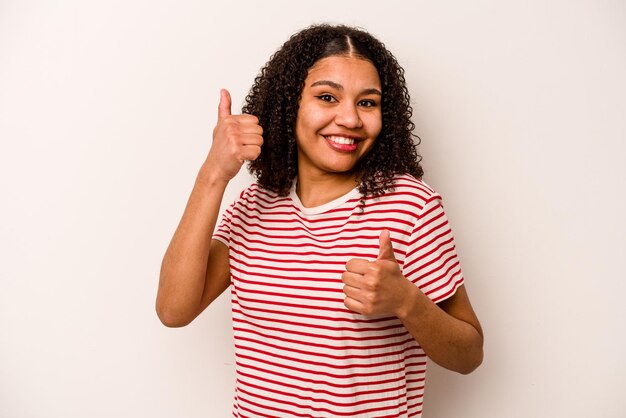 Alzando entrambi i pollici in su sorridente e fiducioso