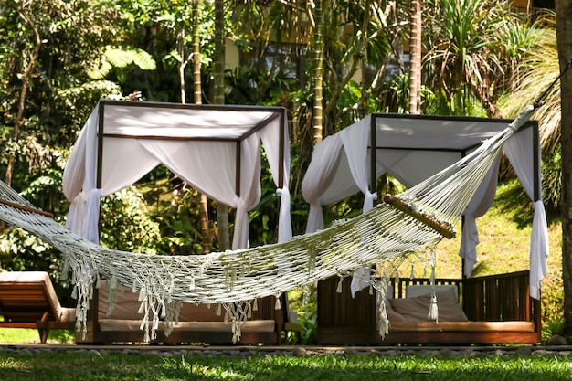 Amaca sul tavolo di accoglienti gazebo, un luogo di riposo e relax in un bellissimo giardino tropicale nell'isola di Bali, Indonesia, orientamento orizzontale