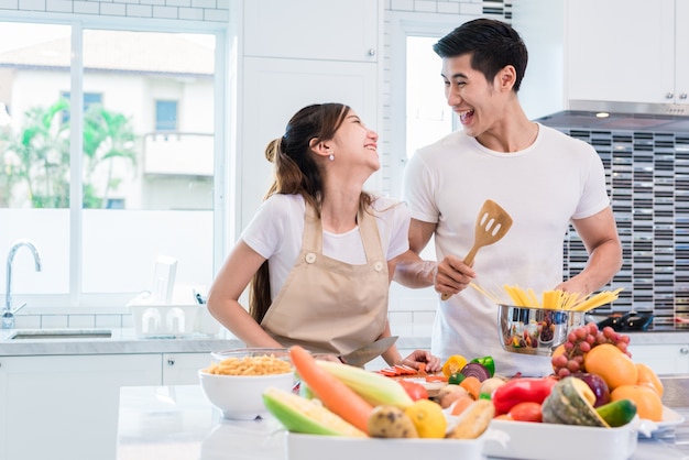 Amanti asiatici o coppie che cucinano in modo così divertente insieme in cucina