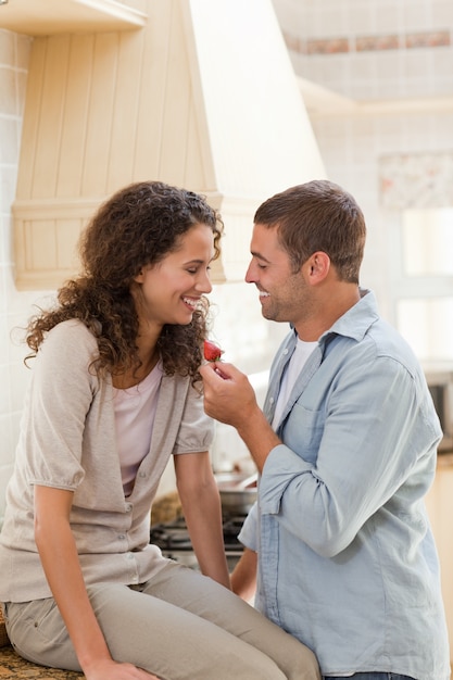 Amanti che mangiano una fragola nella loro cucina