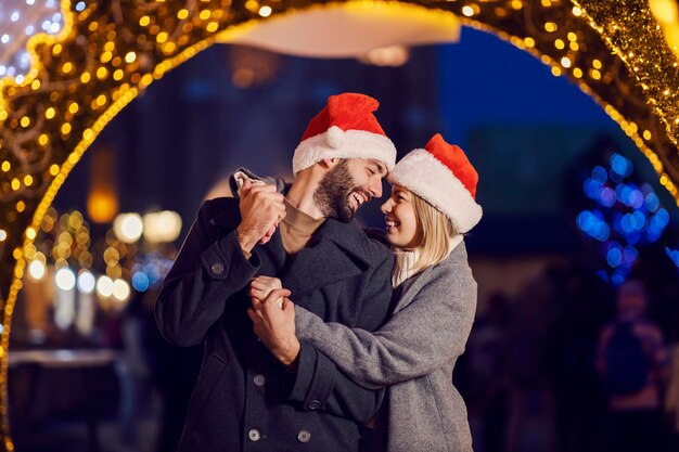Amanti del Natale che si abbracciano per strada la vigilia di Natale