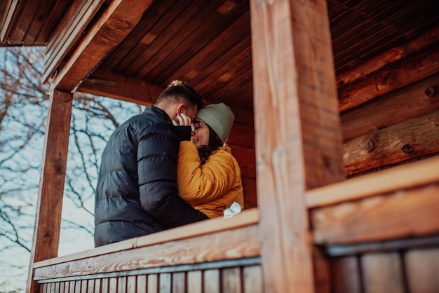 Amare l'uomo e la donna in piedi nel balcone della loro camera cottage