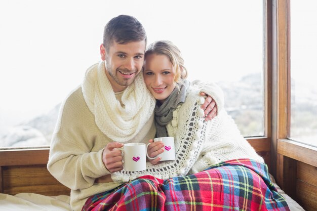 Amare la coppia in inverno indossare con coppe contro la finestra
