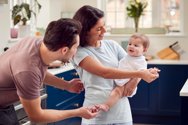 Amare la famiglia transgender con il bambino in cucina a casa insieme