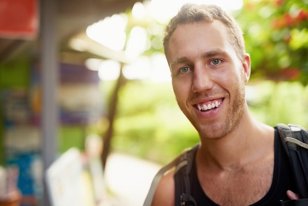 Amare la vita zaino in spalla Ritratto di un giovane sorridente che indossa uno zaino in viaggio in Thailandia