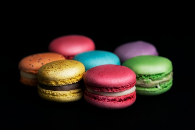 Amaretti francesi dolci e colorati su sfondo nero