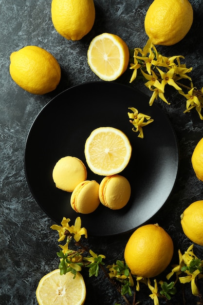 Amaretti, limoni e fiori su sfondo nero affumicato