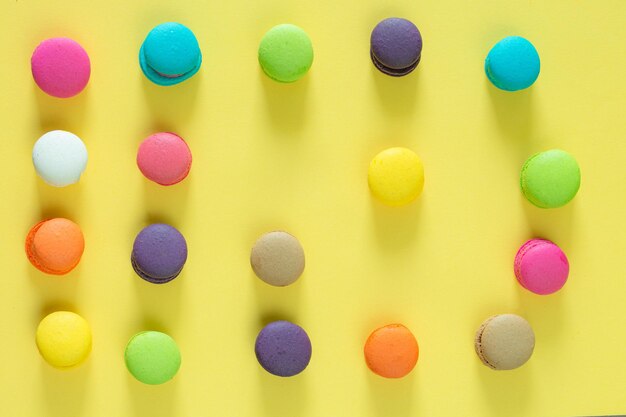 Amaretti o amaretti francesi dolci e colorati su sfondo giallo