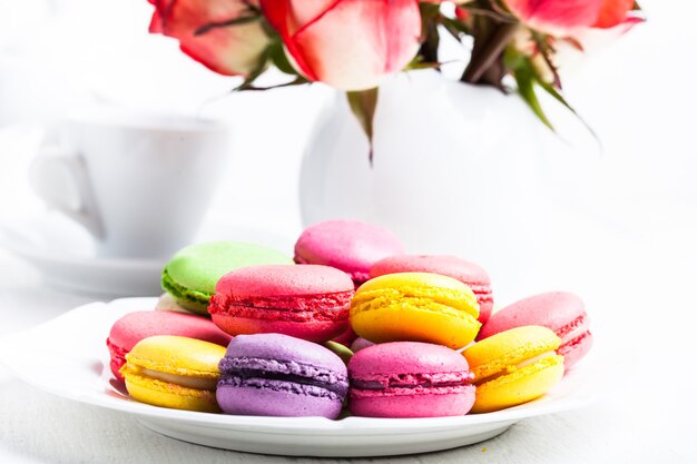 Amaretti sul piatto e rose in vaso. Tabella di compleanno