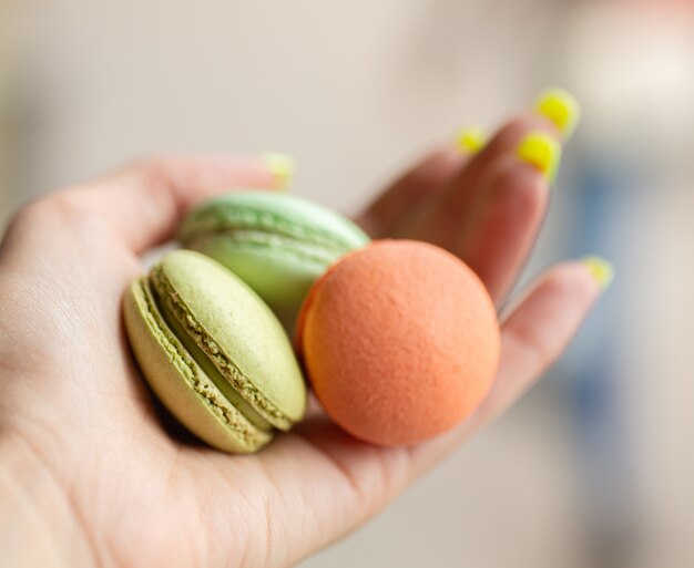 Amaretti verdi e arancioni nella mano