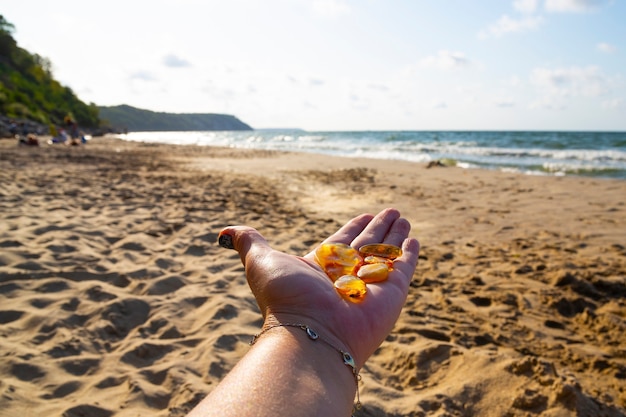 Ambra nel palmo di una mano in spiaggia